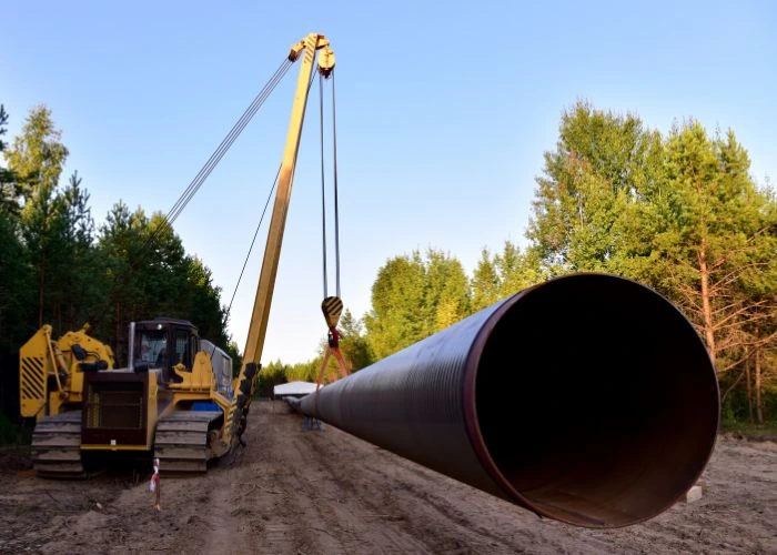 Vinçle doğalgaz boru hattı borusunun hendeğe indirilmesi